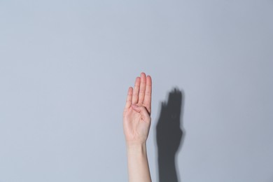 Woman showing open on light grey background, closeup