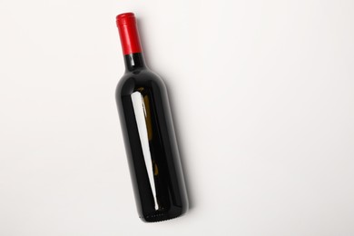 Bottle of expensive red wine on white background, top view. Space for text