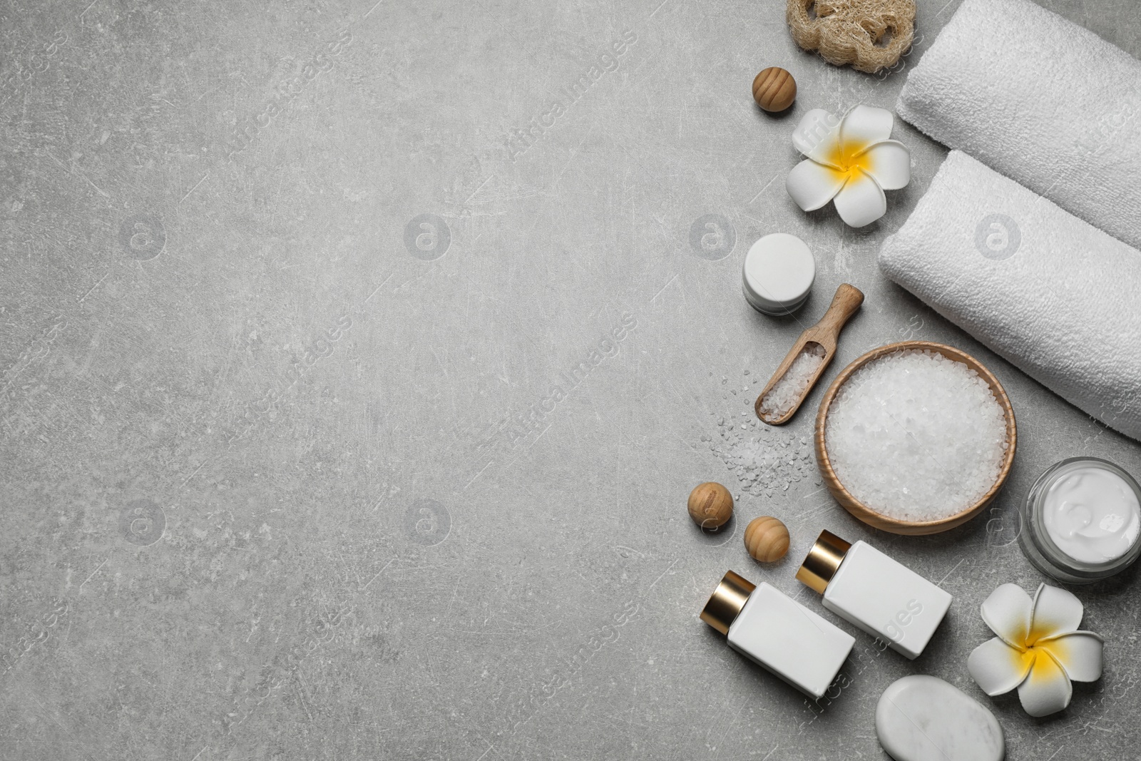 Photo of Flat lay composition with cosmetics and sea salt on grey marble table, space for text. Spa treatment