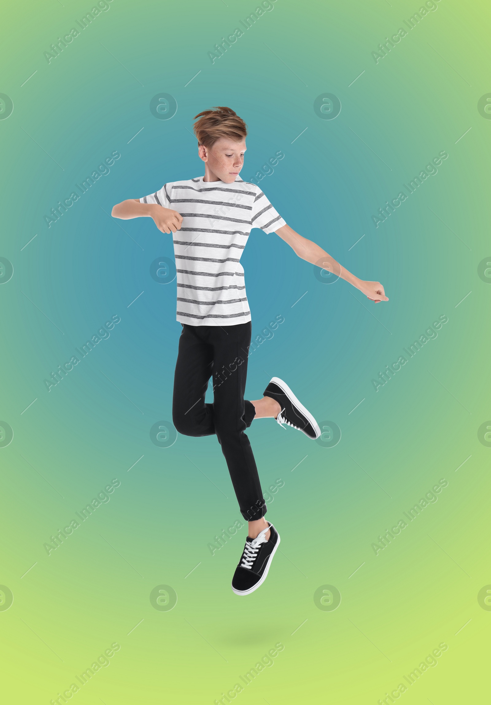 Image of Teenage boy jumping on color gradient background