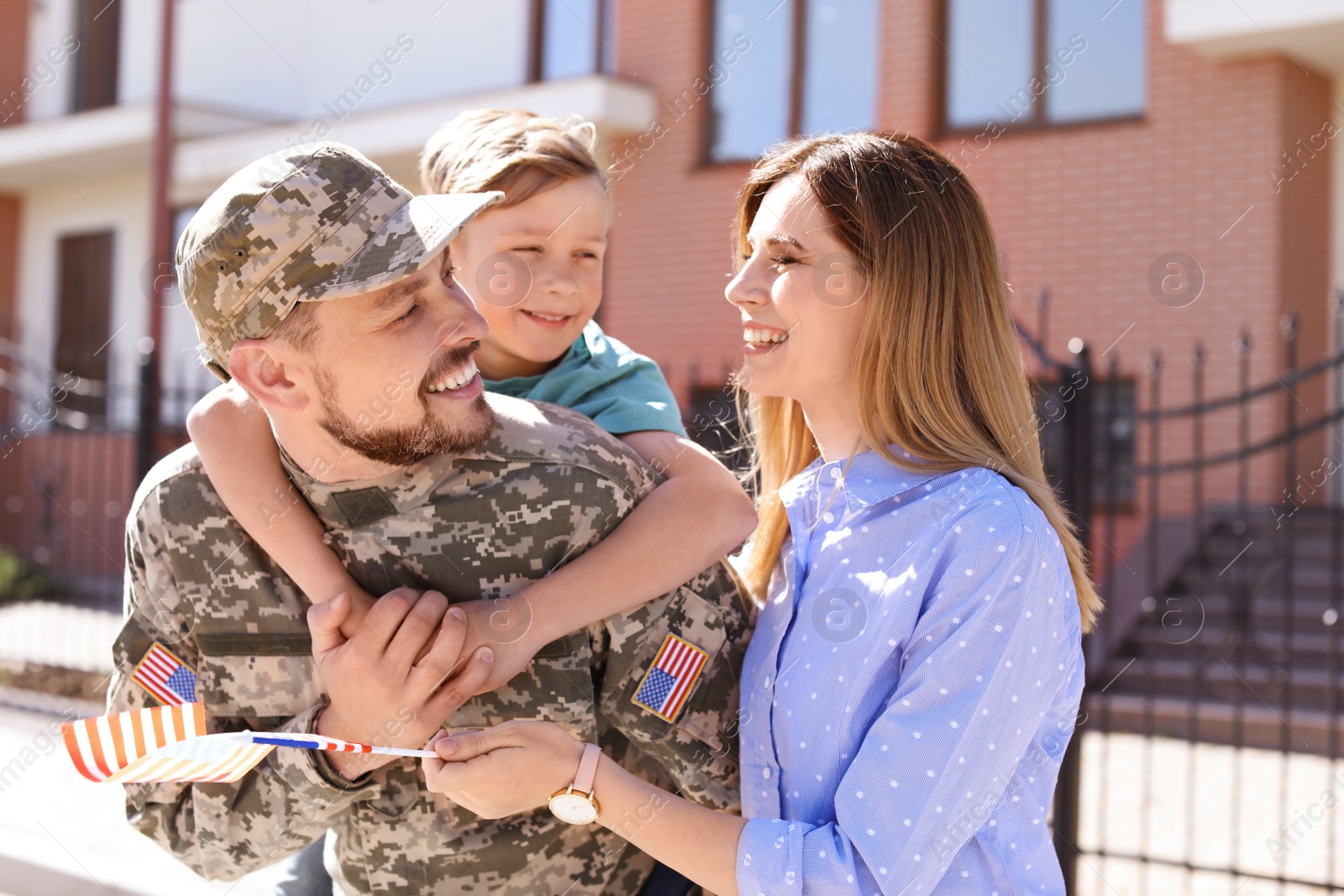 Photo of Male soldier reunited with his family outdoors. Military service