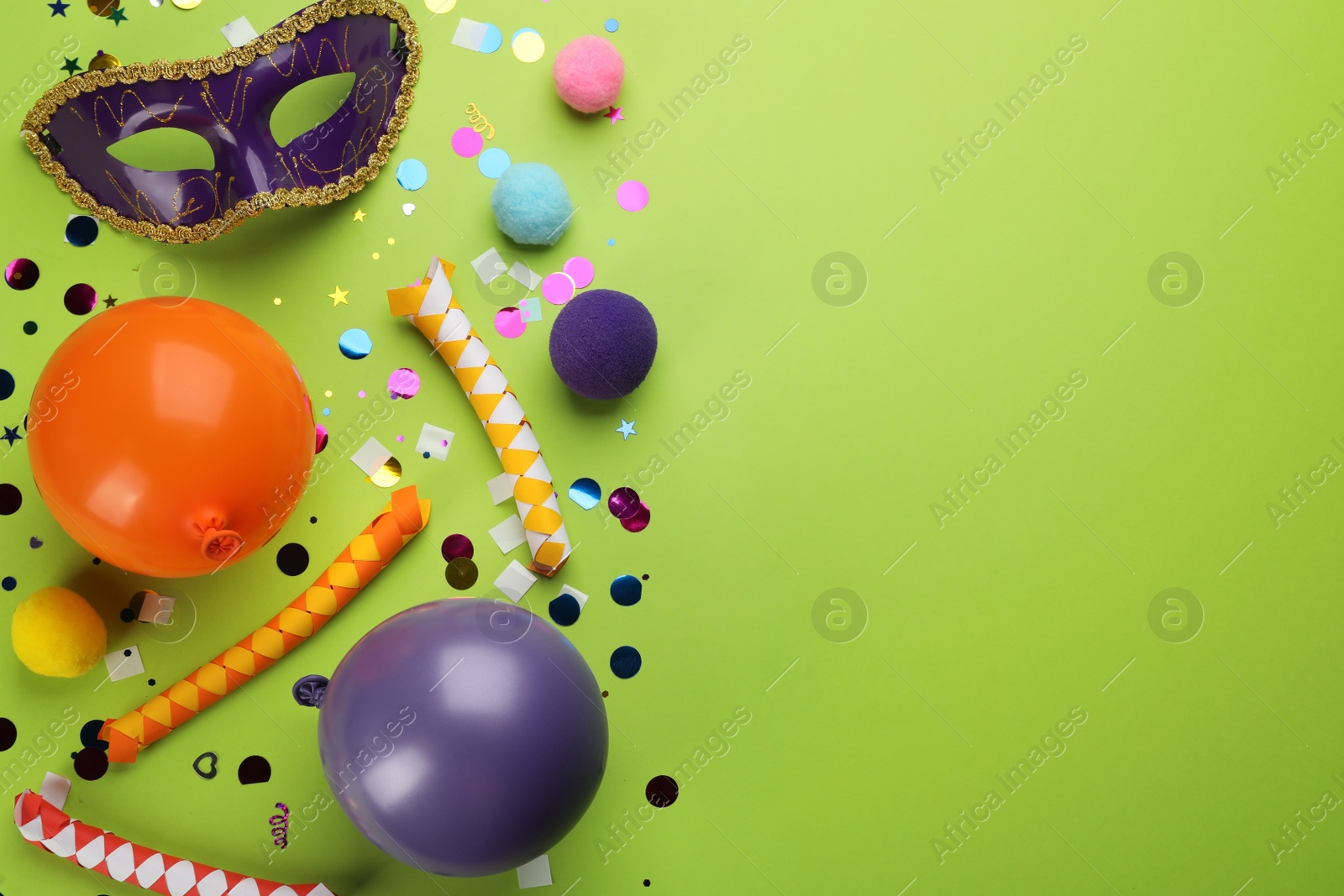 Photo of Flat lay composition with carnival items on green background. Space for text