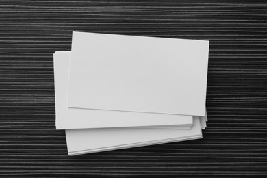 Blank business cards on black wooden table. Mockup for design