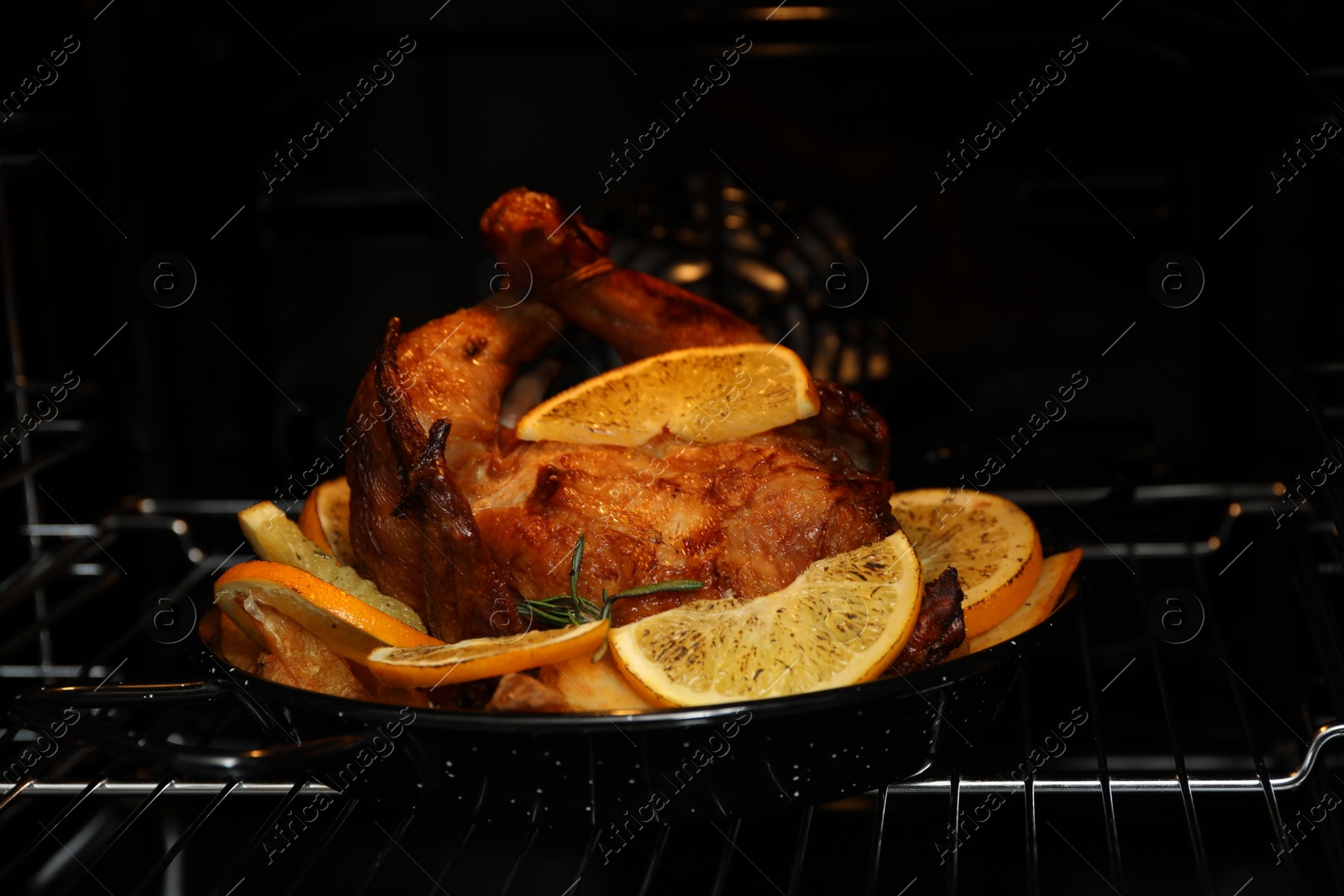 Photo of Chicken with orange slices baking in oven