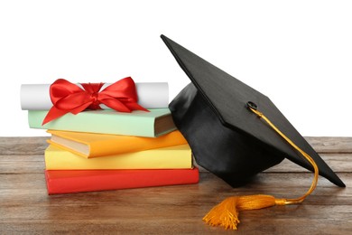 Graduation hat, books and diploma on wooden table against white background