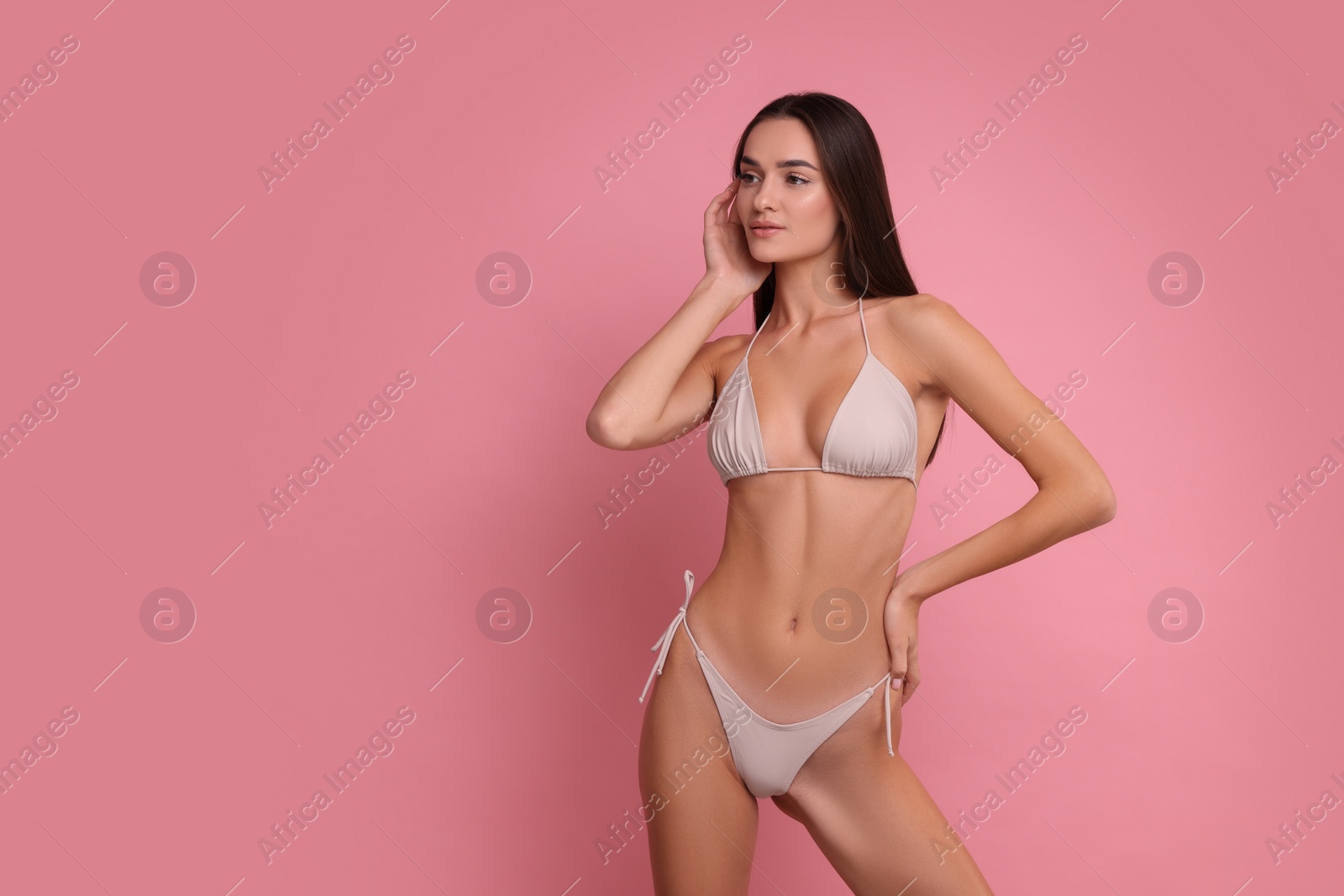 Photo of Young woman in stylish bikini on pink background, space for text