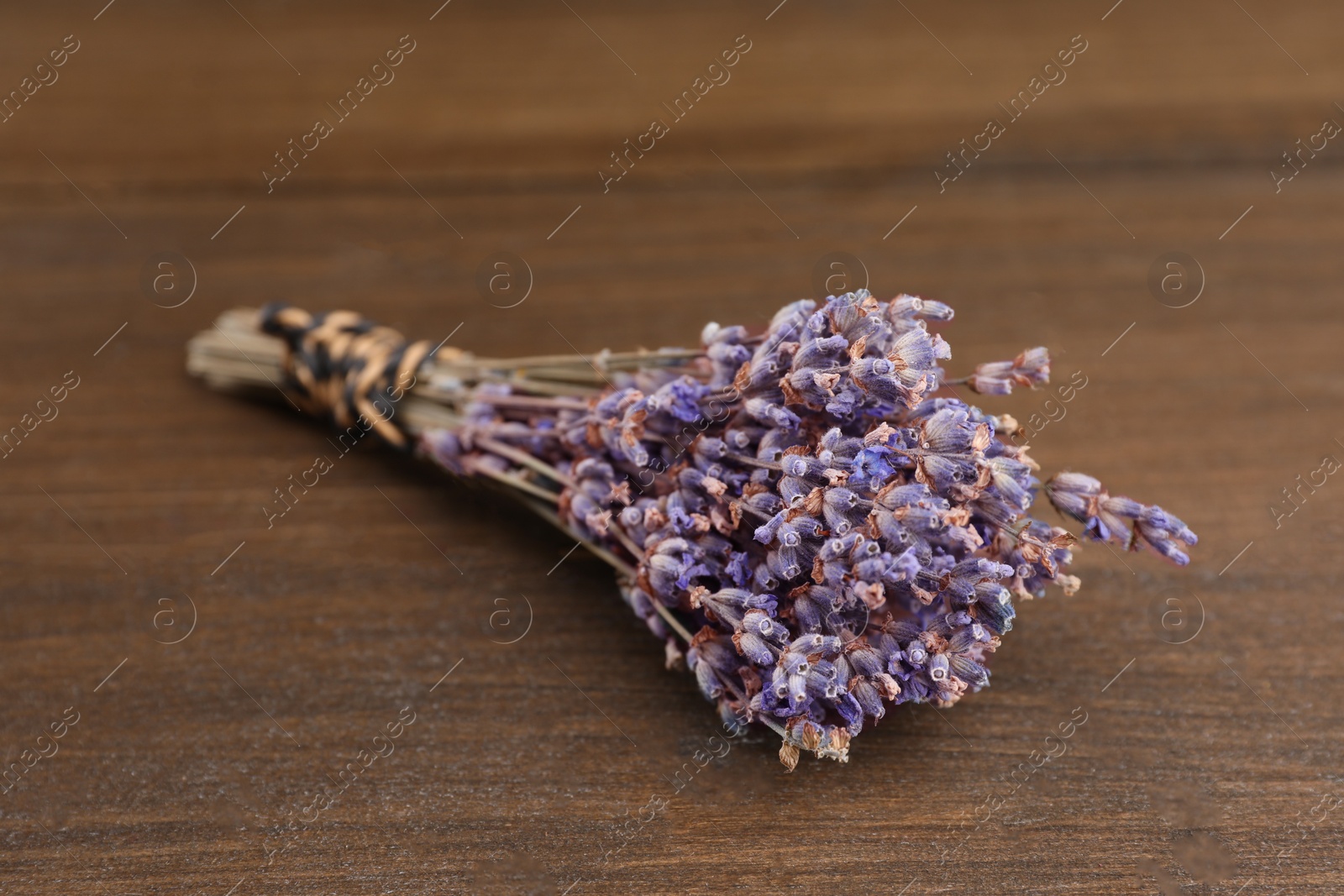 Photo of Bunch of dry lavender on wooden table, closeup