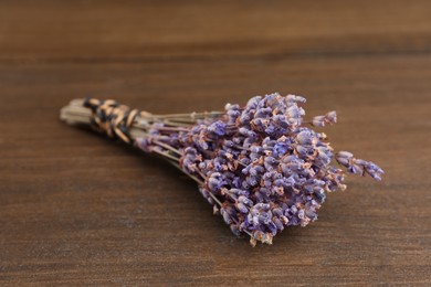 Photo of Bunch of dry lavender on wooden table, closeup