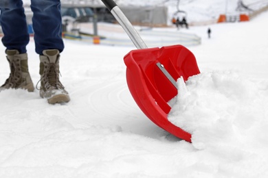 Photo of Man removing snow with shovel outdoors. Winter weather