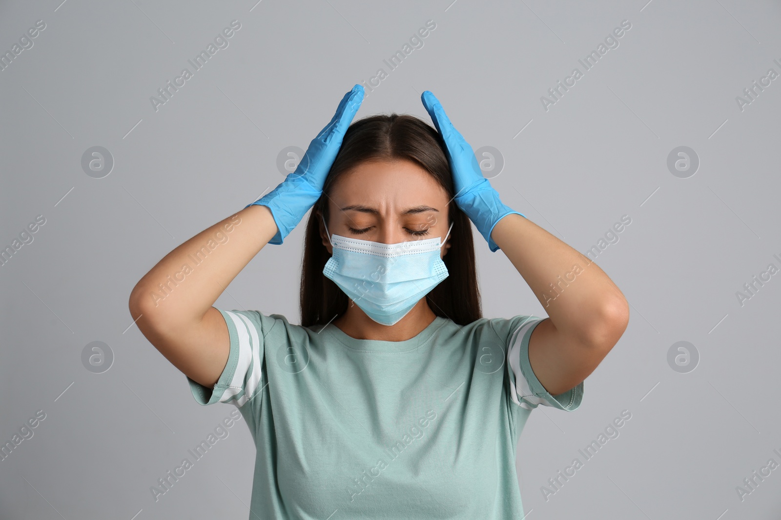 Photo of Stressed woman in protective mask on grey background. Mental health problems during COVID-19 pandemic