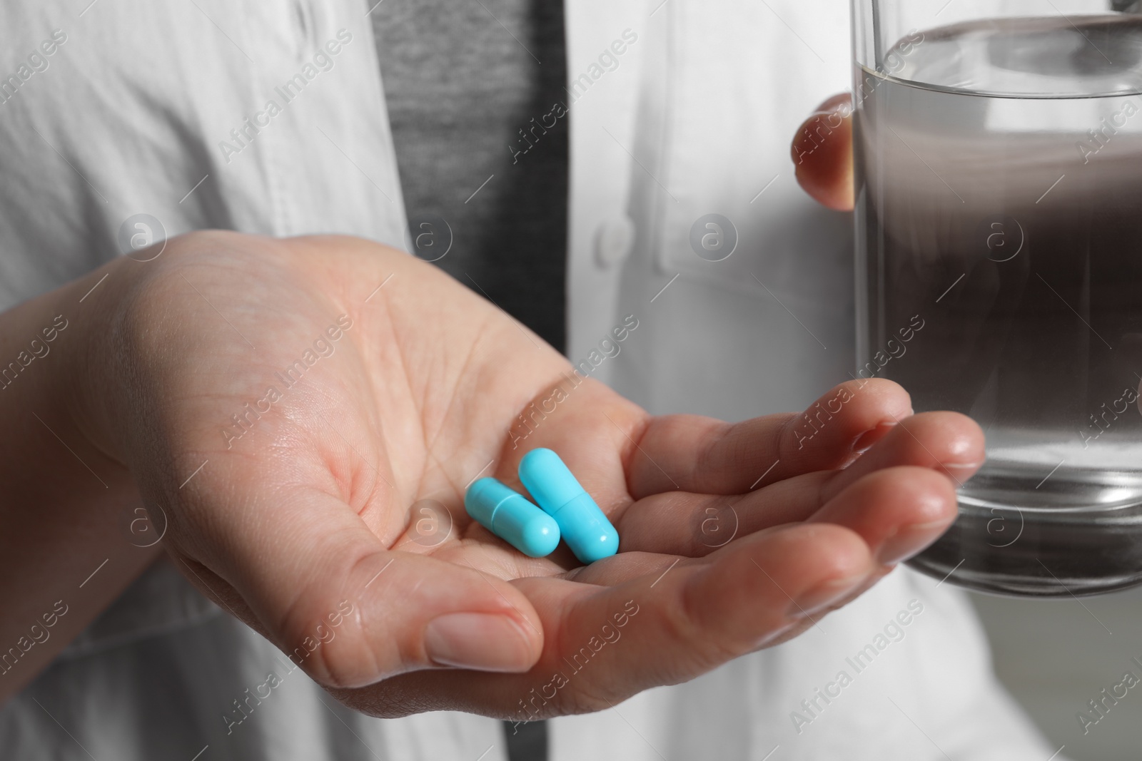 Photo of Woman with pills and glass of water, closeup
