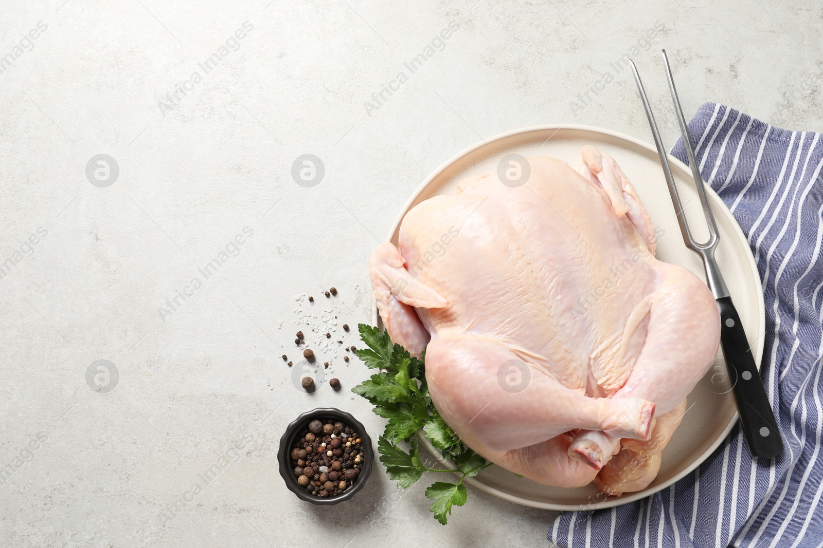 Photo of Fresh raw chicken with spices and fork on light grey table, flat lay. Space for text
