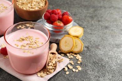 Photo of Glass of tasty berry smoothie with oatmeal on grey table. Space for text