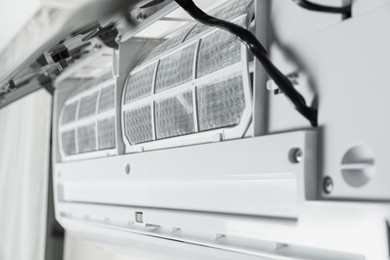 Photo of Modern air conditioner on white wall indoors, closeup view