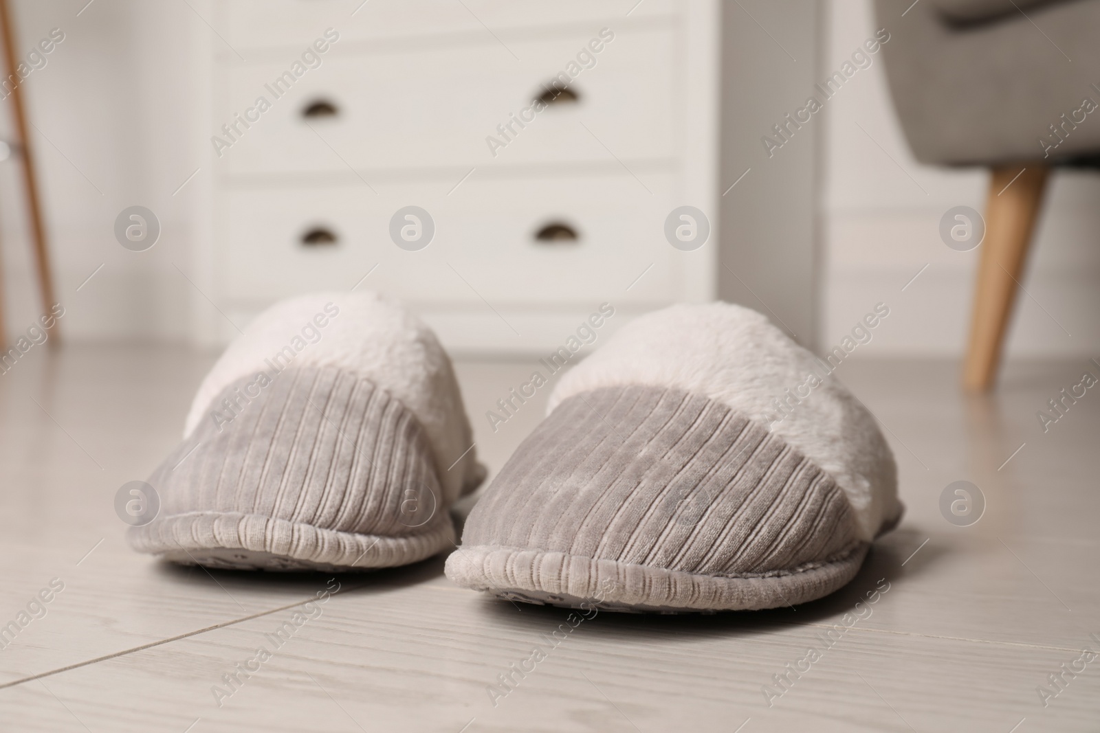 Photo of Grey warm slippers on floor in room