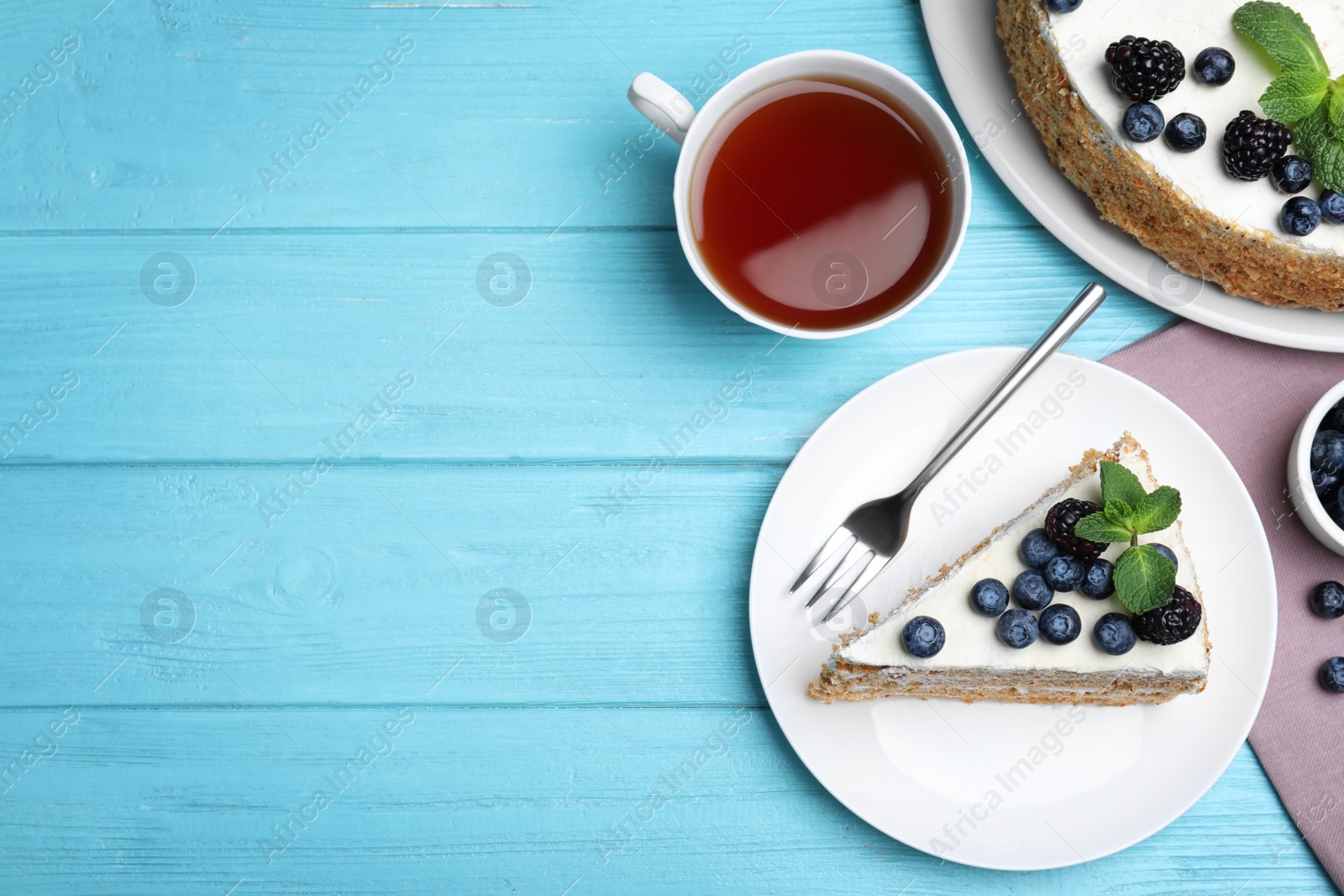 Photo of Delicious cake with blueberries on light blue wooden table, flat lay. Space for text