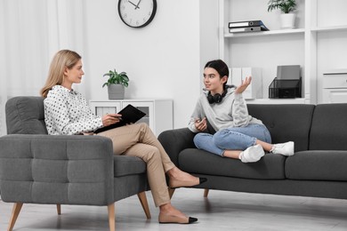 Psychologist working with teenage girl in office