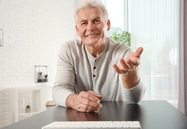 Photo of Mature man using video chat at home, view from web camera