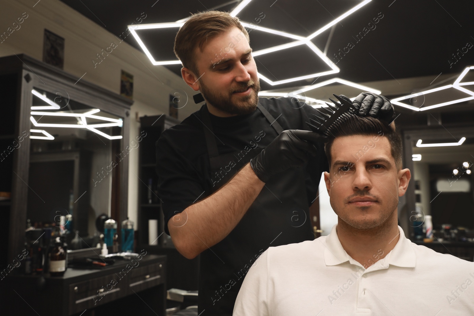 Photo of Professional hairdresser making stylish haircut in salon