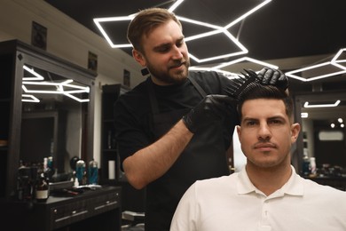 Photo of Professional hairdresser making stylish haircut in salon