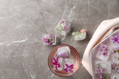 Photo of Flat lay composition with floral ice cubes on table. Space for text