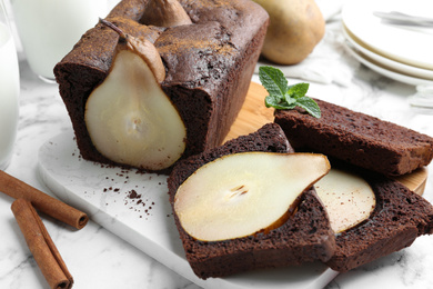 Photo of Tasty pear bread with mint and cinnamon on white marble table. Homemade cake