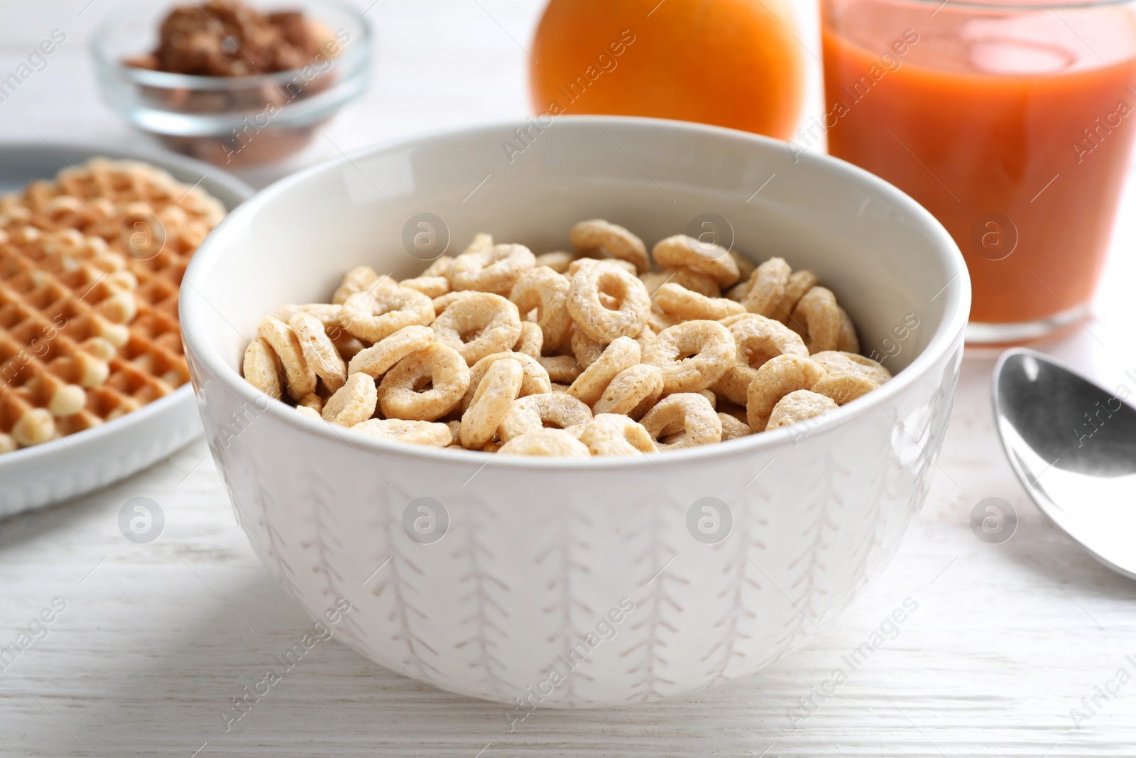 Photo of Corn rings on white wooden table, closeup. Healthy breakfast