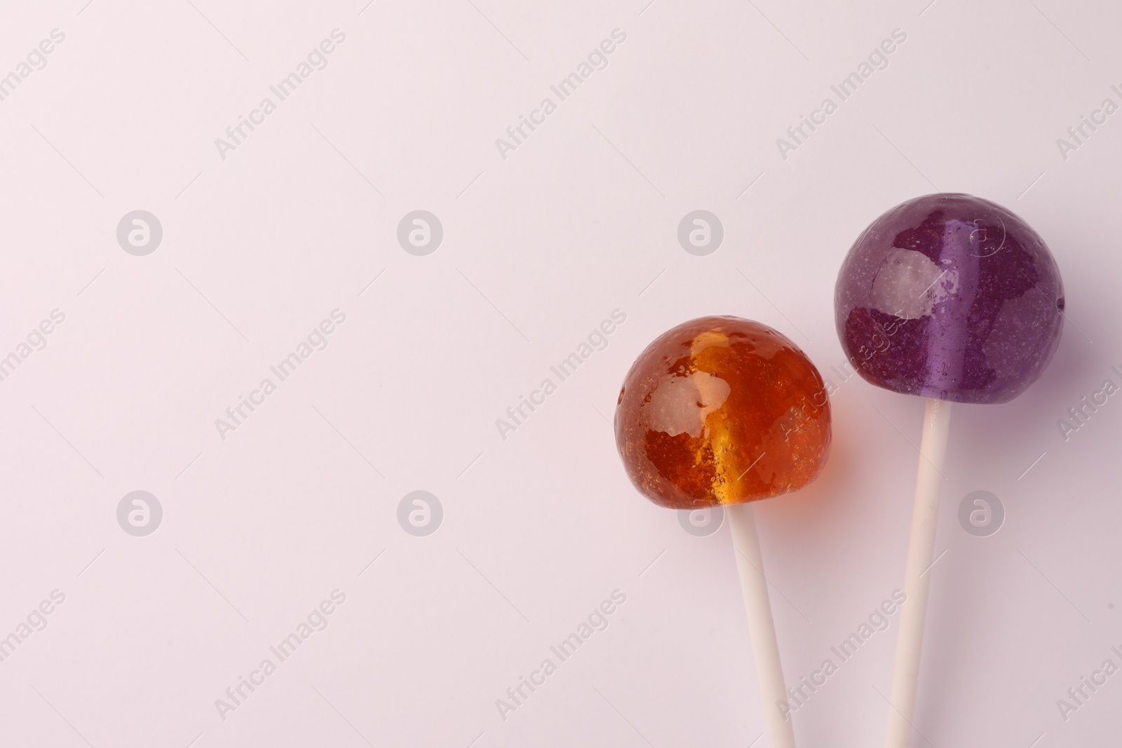 Photo of Tasty lollipops on white background, flat lay. Space for text