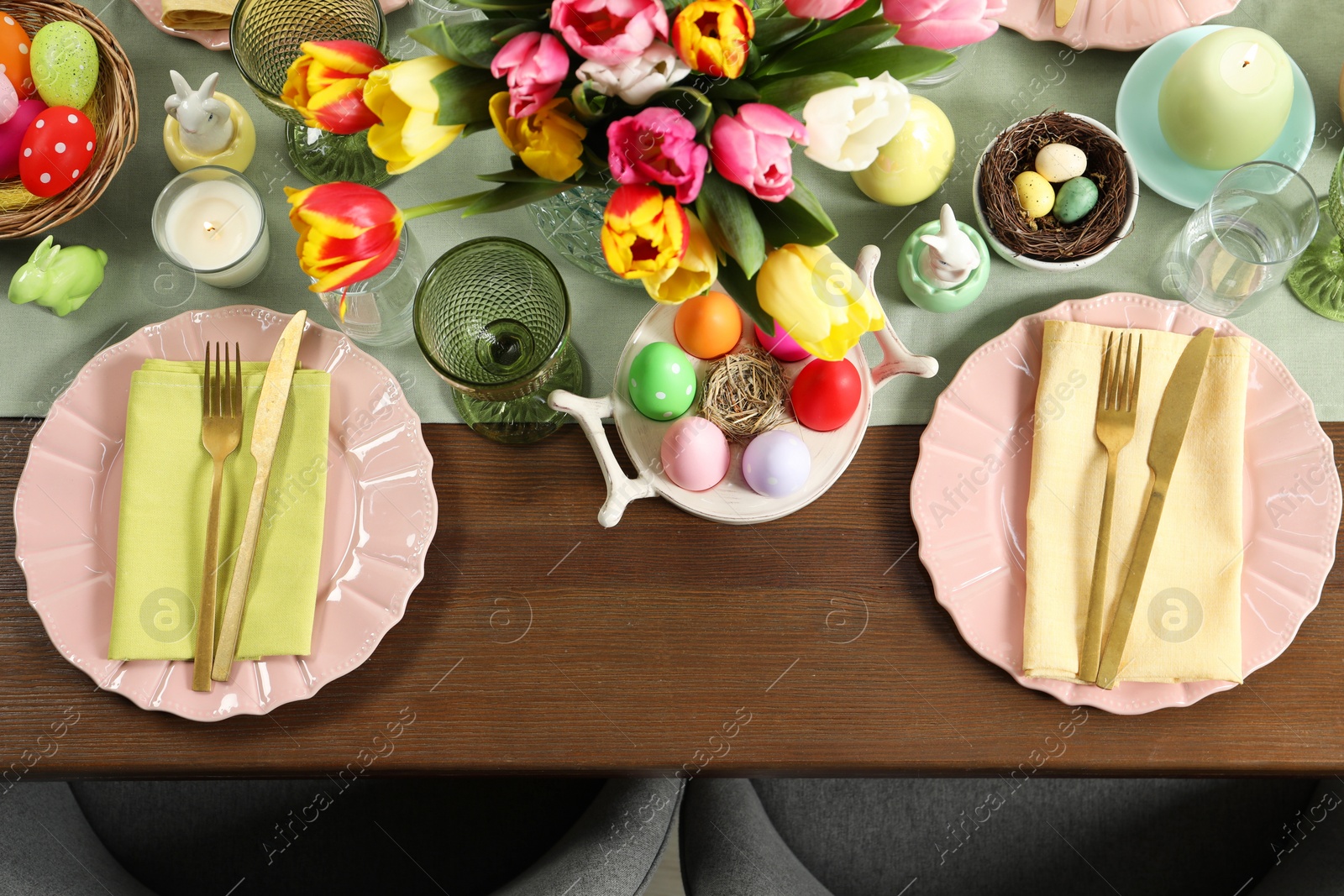 Photo of Festive Easter table setting with beautiful flowers and painted eggs, top view