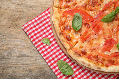 Photo of Delicious pizza Margherita on wooden table, top view