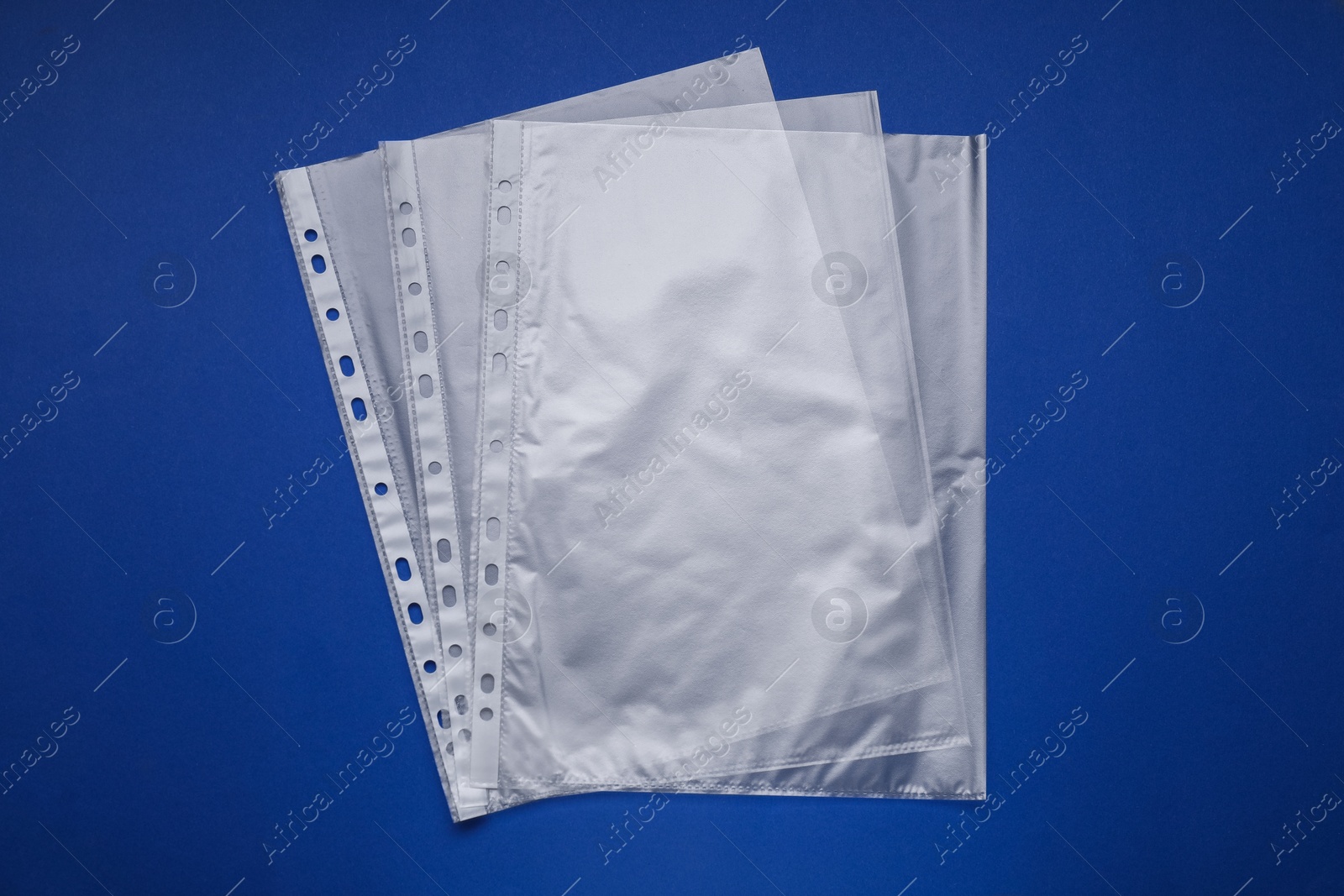 Photo of Punched pockets on blue background, flat lay