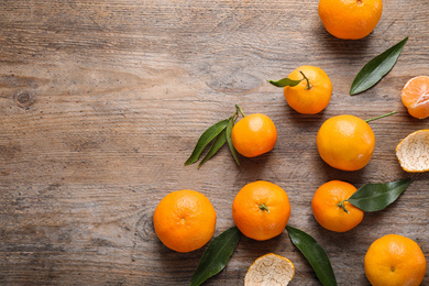 Photo of Fresh ripe tangerines on wooden table, flat lay. Space for text