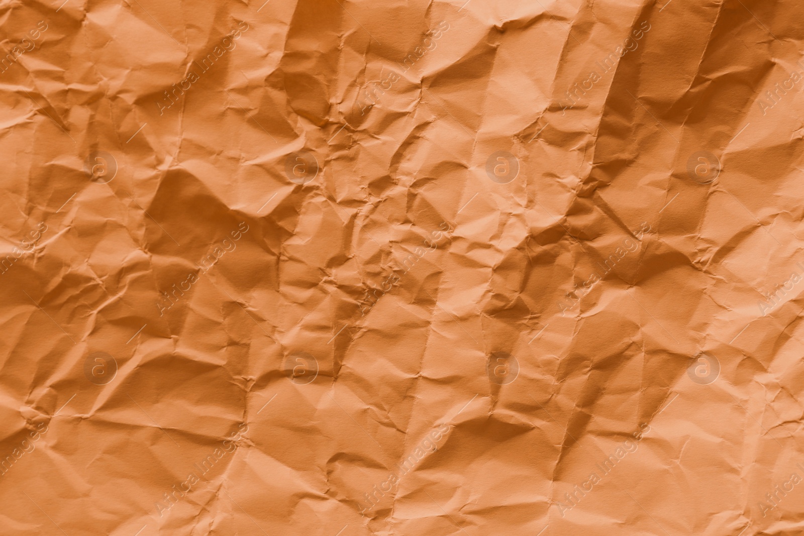 Photo of Texture of orange crumpled paper as background, top view