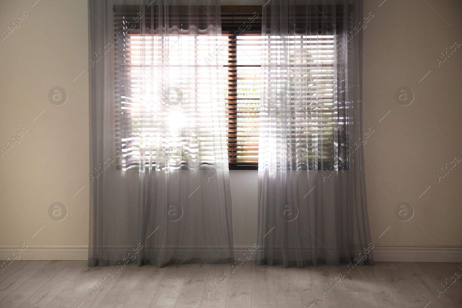 Photo of Window with beautiful curtains and blinds in empty room