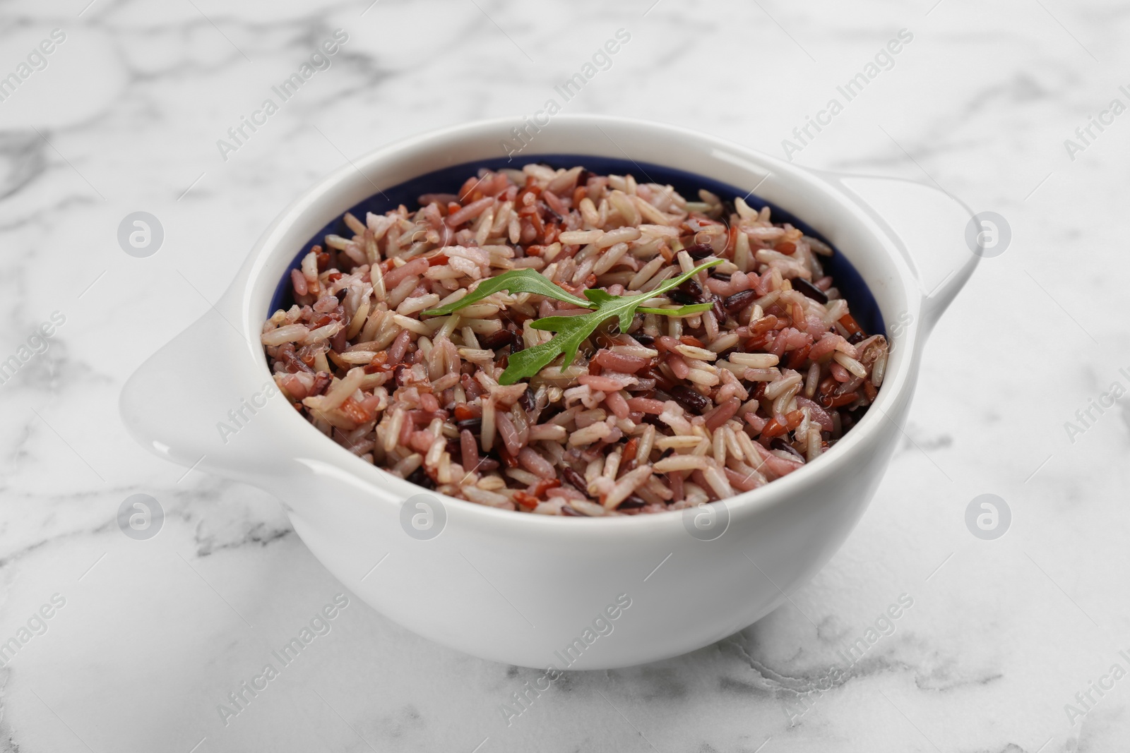 Photo of Tasty brown rice on marble table, closeup