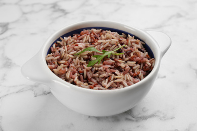 Photo of Tasty brown rice on marble table, closeup