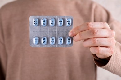Photo of Woman holding blister of antidepressants with happy emoticons, closeup view