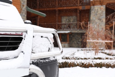 Car covered with snow after storm outdoors on beautiful winter day, closeup. Space for text