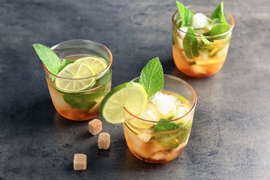 Glasses with delicious mint julep cocktail on grey table