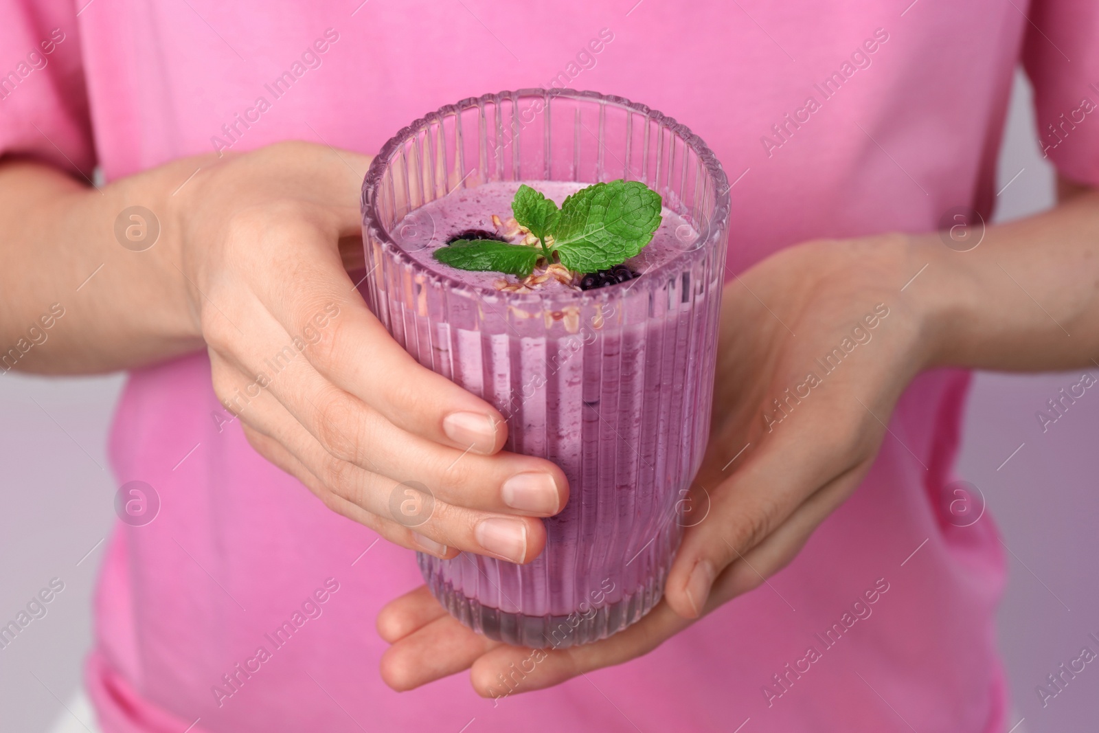 Photo of Woman with glass of delicious blackberry smoothie on white background, closeup