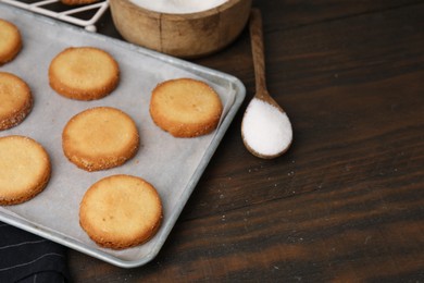 Photo of Tray with tasty sweet sugar cookies on wooden table, closeup. Space for text