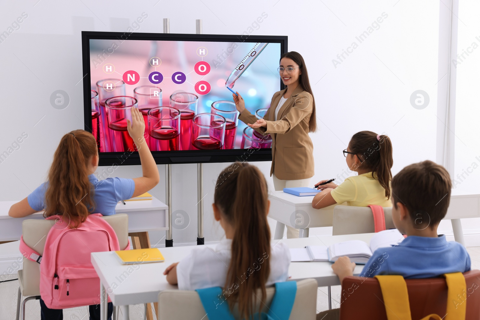 Photo of Teacher using interactive board in classroom during lesson