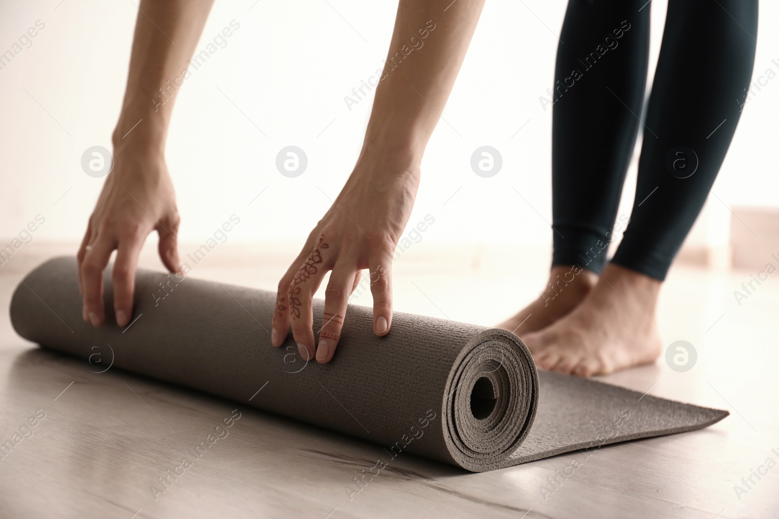 Photo of Young woman with yoga mat indoors, closeup