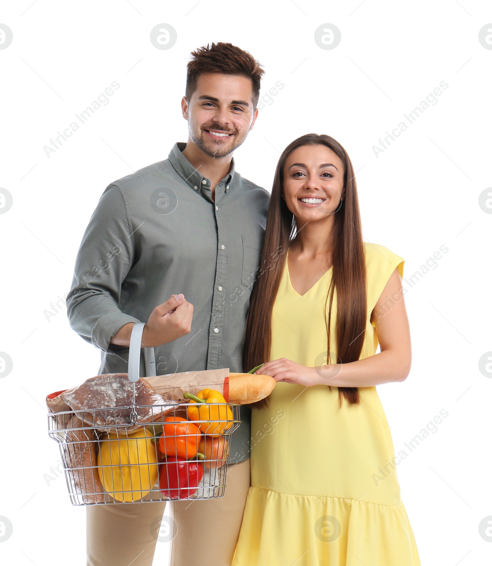 Photo of Young couple with shopping basket full of products isolated on white