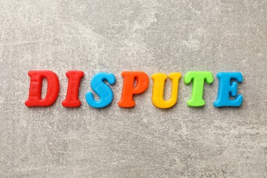 Photo of Word Dispute made of colorful letters on grey table, flat lay