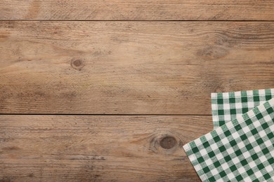 Photo of Checkered tablecloth on wooden table, top view. Space for text