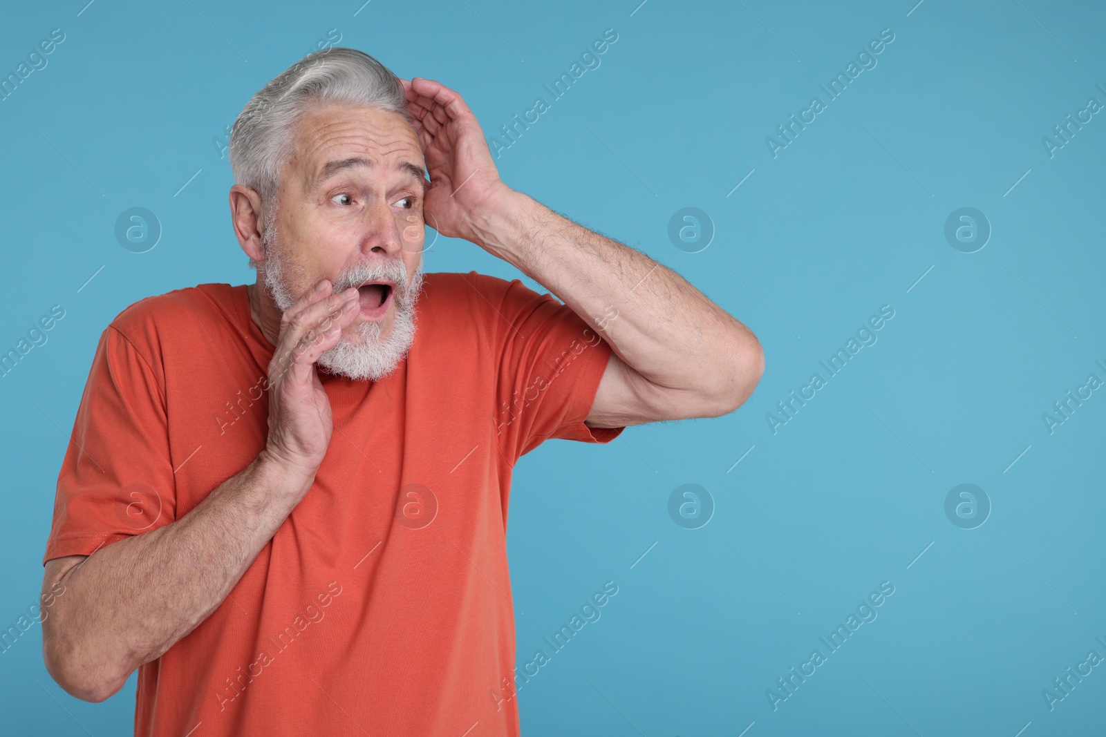 Photo of Portrait of surprised senior man on light blue background, space for text