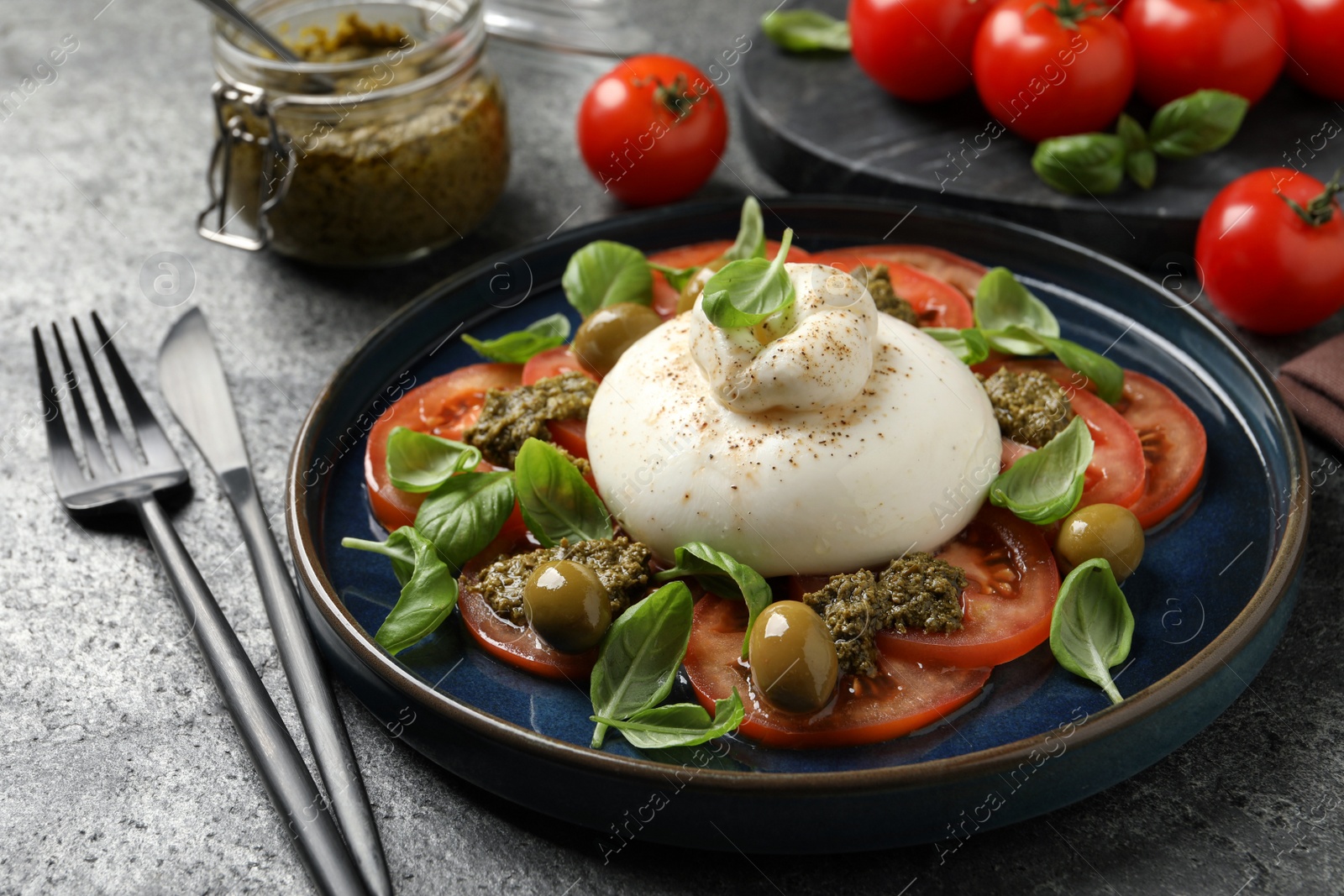 Photo of Delicious burrata salad served on grey table