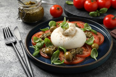 Photo of Delicious burrata salad served on grey table