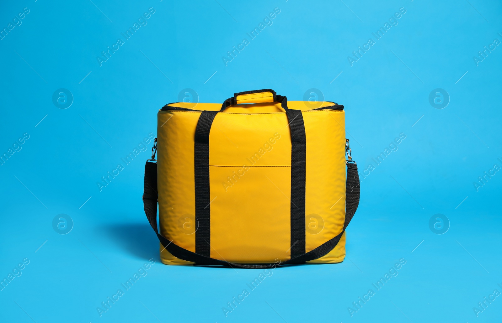 Photo of Modern yellow thermo bag on light blue background
